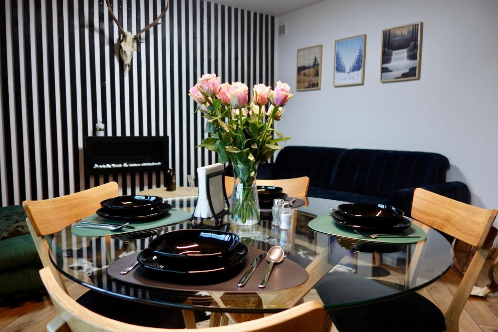 - une table à manger avec un vase de fleurs dans l'établissement Widok 3B, à Piechowice