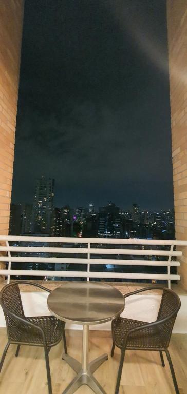 サンパウロにあるTRIPEX cobertura DIFERENCIADO NYC BERRINI SAO PAULOの街の景色を望むバルコニーに置かれたテーブルと椅子