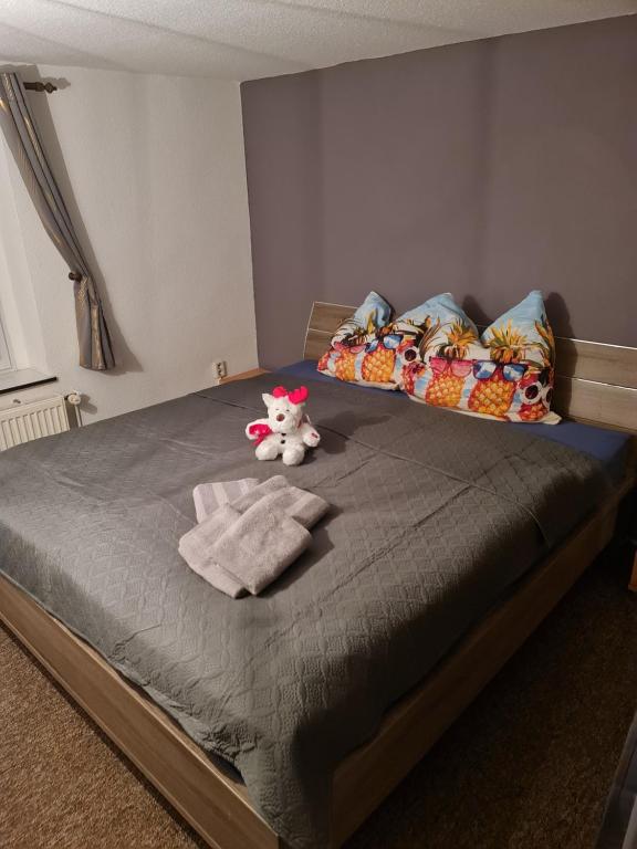 a bedroom with a bed with a stuffed animal on it at Ferienwohnungen Fam. Bartl in Bad Suderode