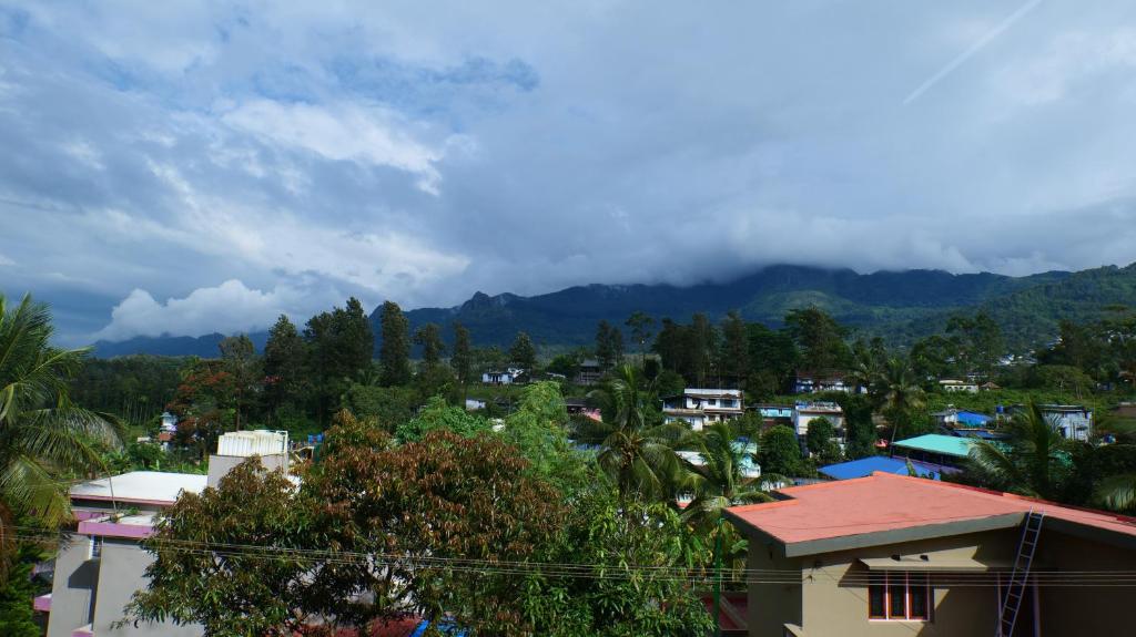 a view of a city with mountains in the background at Hillside Hideaway Gudalur in Gūdalūr