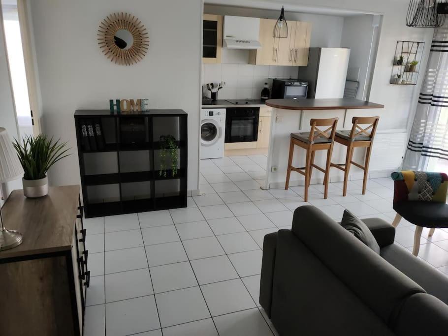 a living room with a couch and a kitchen at Spacieux et joli appartement de 2 à 4 personnes • Parking • Wifi in Fenouillet