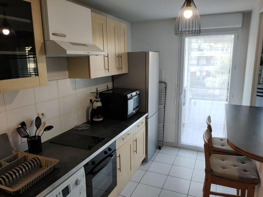 a kitchen with a refrigerator and a microwave at Spacieux et joli appartement de 2 à 4 personnes • Parking • Wifi in Fenouillet