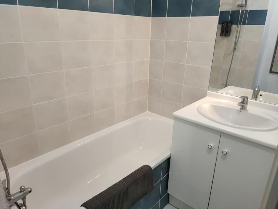 a bathroom with a white tub and a sink at Spacieux et joli appartement de 2 à 4 personnes • Parking • Wifi in Fenouillet