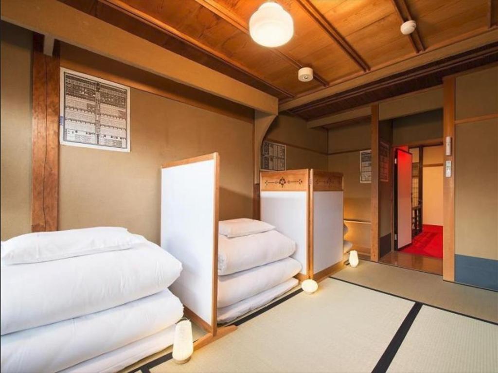 a room with two beds and a refrigerator at ダース旅館＆カフェ（Dozen-Ryokan＆Cafe） in Nishi-kujō-Toriiguchichō