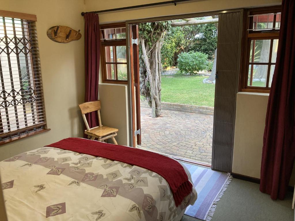 a bedroom with a bed and a sliding glass door at Paradise in Kommetjie in Cape Town