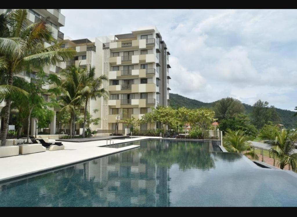 uma piscina em frente a um edifício em By The Sea Batu Ferringhi Beach Front Apartment Suite em Batu Ferringhi