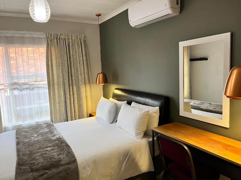 a hotel room with a bed and a window at UStay Apartment - Westdene in Bloemfontein