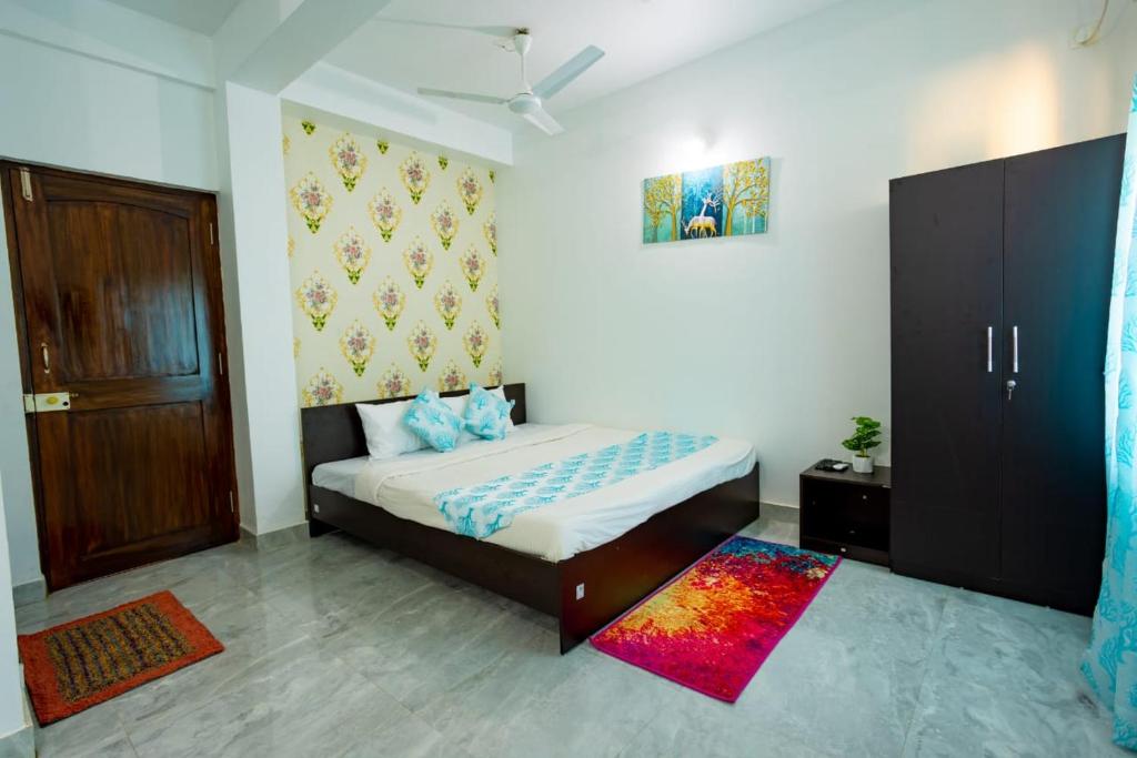 a bedroom with a bed and a wooden door at Goan Fiesta Studio CALANGUTE GOA in Calangute
