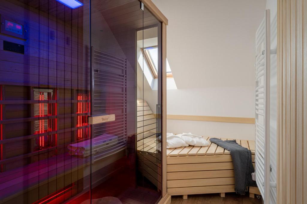 a bathroom with a glass shower with a bed in it at Kapocs Apartmanház in Borgáta