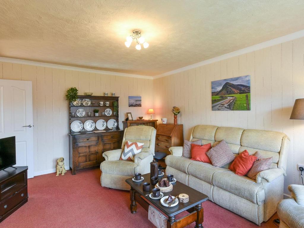 a living room with two couches and a tv at Maldwyn in Llanegryn