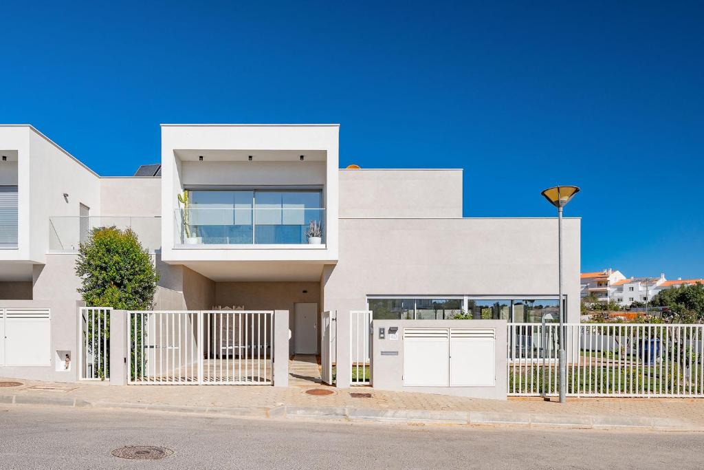 una casa bianca con un cancello e una recinzione di Casa MarTan, by Ideal Homes - Deluxe Villa a Parchal