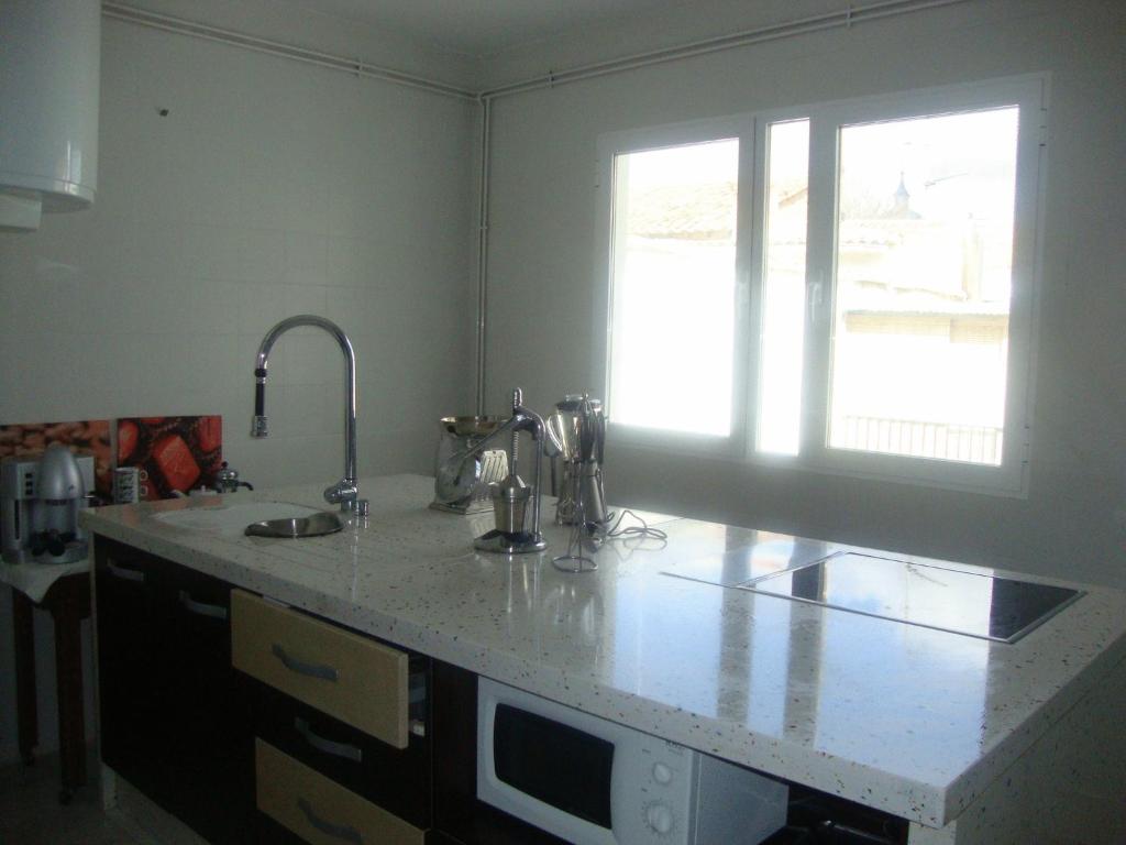 a kitchen with a counter with a sink and a window at Casa De Comedias in Almagro