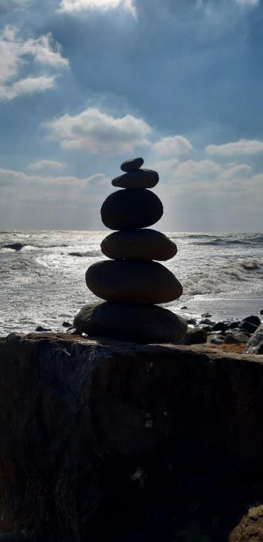 uma pilha de pedras sentadas na praia em Kaia Penthouse, waking up to the sound and smell of the ocean em Ventnor