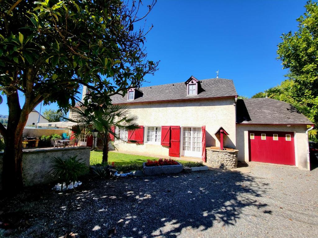 una casa roja y blanca con dos puertas de garaje en TI CAZ PYRENEES (Chambre d'Hôtes), en Mirepeix