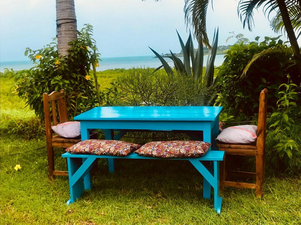 a blue bench with two pillows on top of it at Corto Novo Maison d'hôtes-Camping in Nosy Be
