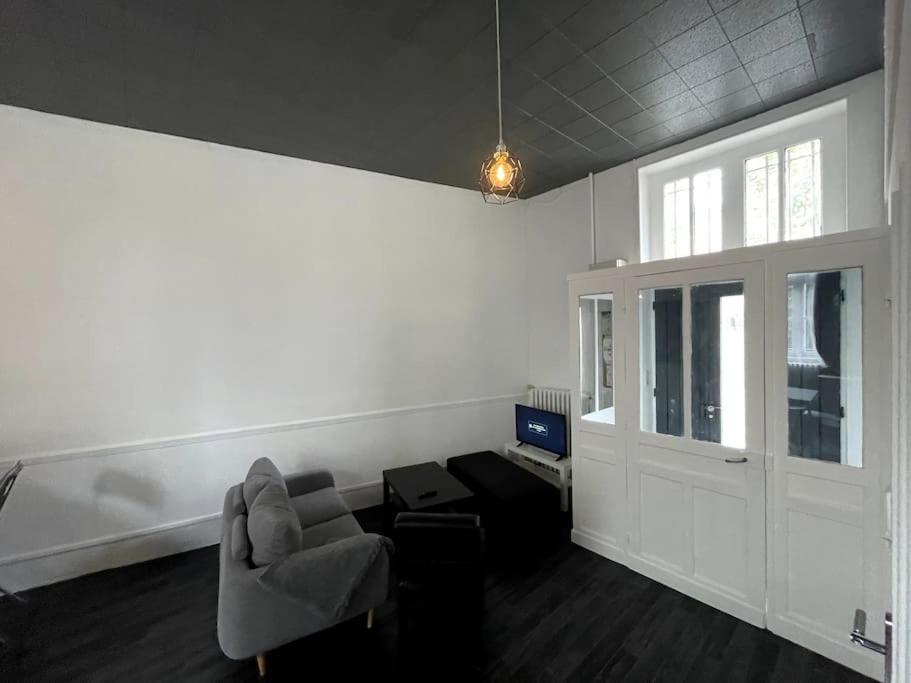 a living room with a couch and a chair and a computer at Agréable maison de ville dans la plus belle Avenue in Orléans