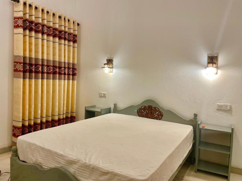 ein Schlafzimmer mit einem Bett und einem Vorhang in der Unterkunft ALOHA Second Home in Tangalle