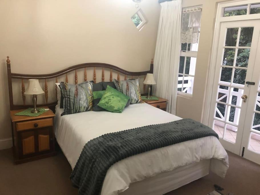 a bedroom with a bed and two lamps and a window at Lovely rental unit with No loadshedding in Sandton