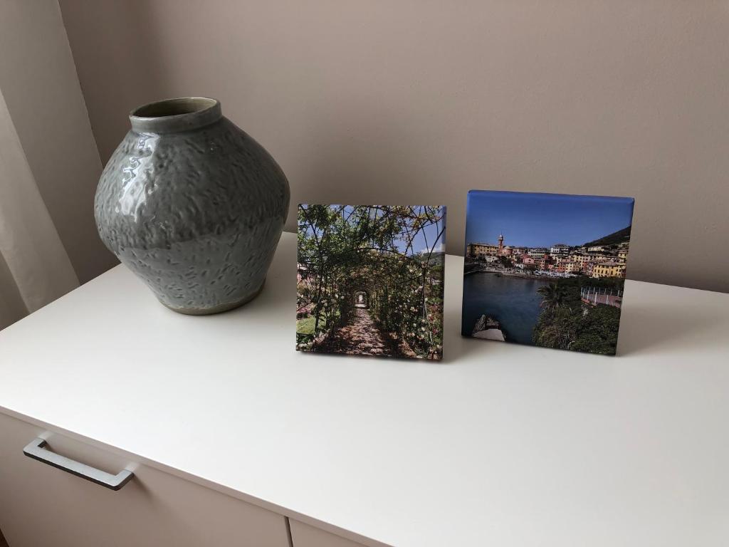 a vase sitting on a table with three pictures at Casa mia a Nervi in Genoa