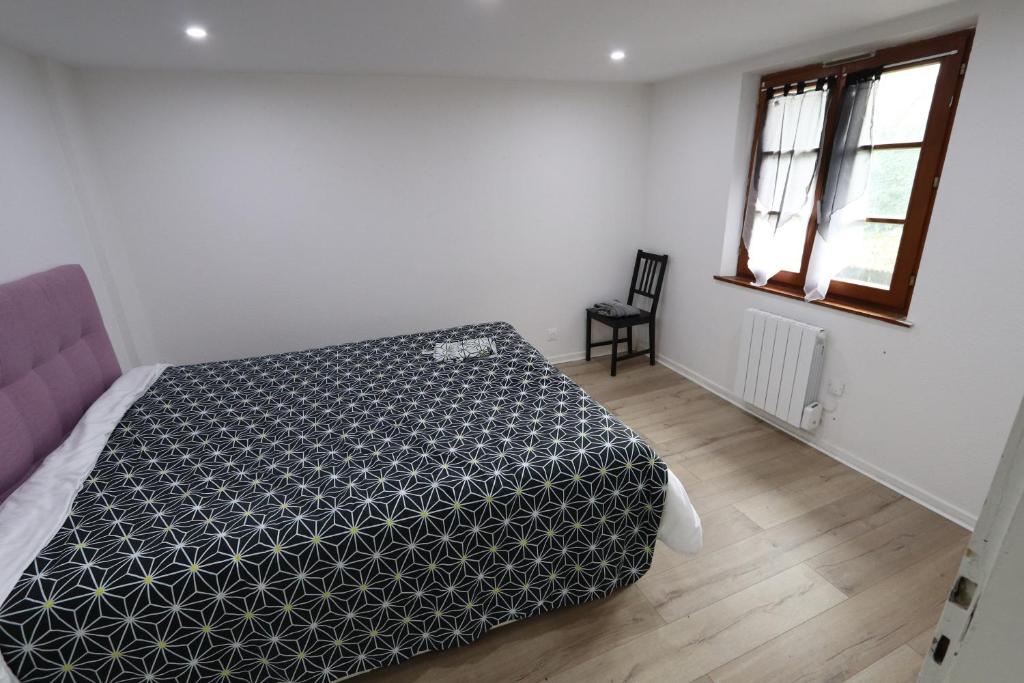 1 dormitorio con 1 cama con manta blanca y negra en HOMEDAY F2 tous confort très bien placé num4, en Haguenau
