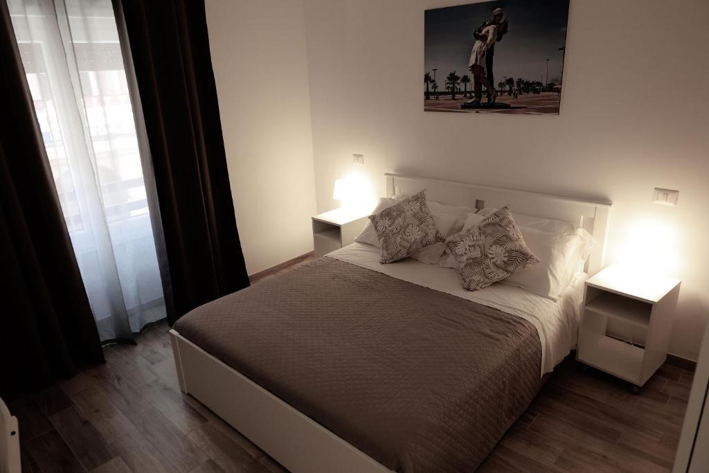 1 dormitorio con 1 cama con 2 mesitas de noche y 2 lámparas en Central Guest House, en Civitavecchia