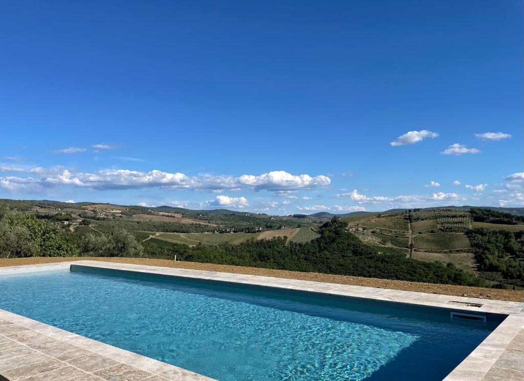 een zwembad met uitzicht op de heuvels bij Casa PRATOLINO in Greve in Chianti