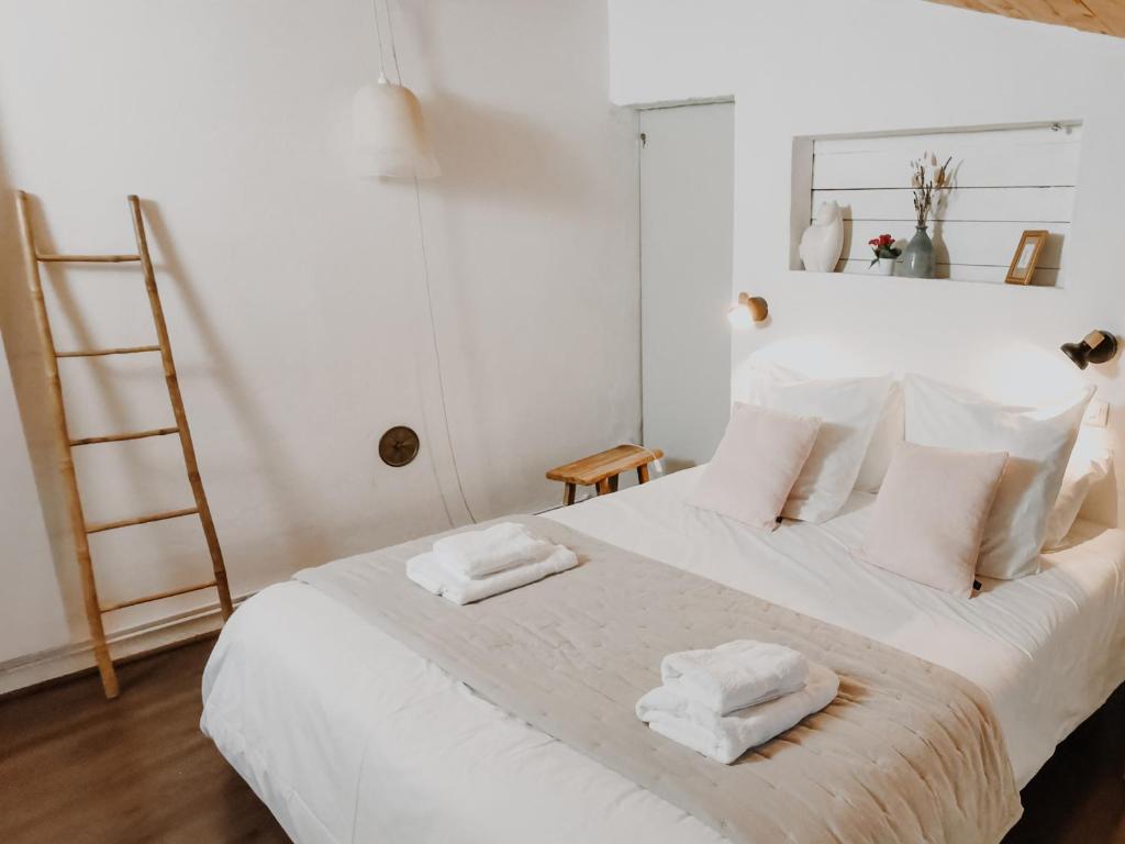 a bedroom with a white bed with two towels on it at Maison de village dans le Luberon in Oppedette