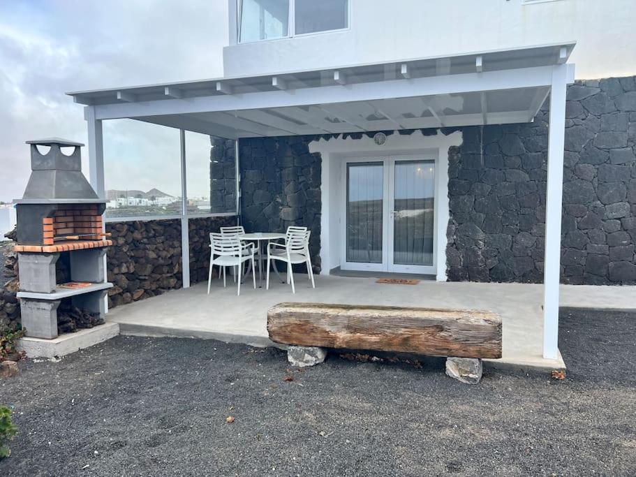 une terrasse avec une cuisinière, une table et des chaises dans l'établissement El Cercado, à Tinajo