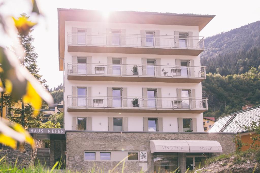 a tall white building with balconies on it at Nefer, Haus in Bad Gastein