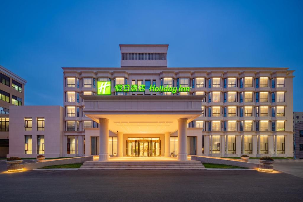 un edificio de hotel con un cartel encima en Holiday Inn Zhengzhou Zhongzhou, an IHG Hotel en Zhengzhou