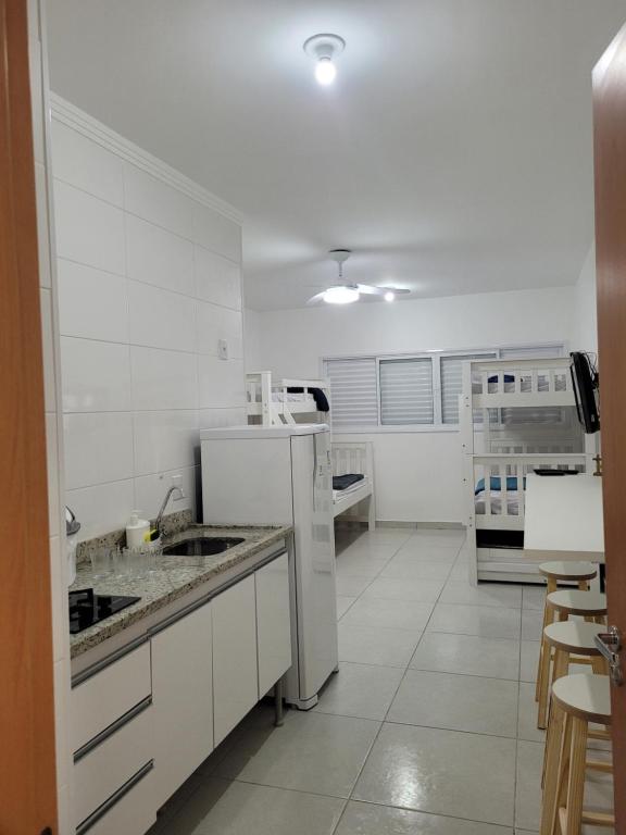 - une cuisine blanche avec des armoires et des appareils blancs dans l'établissement Apartamento Canção Nova, à Cachoeira Paulista