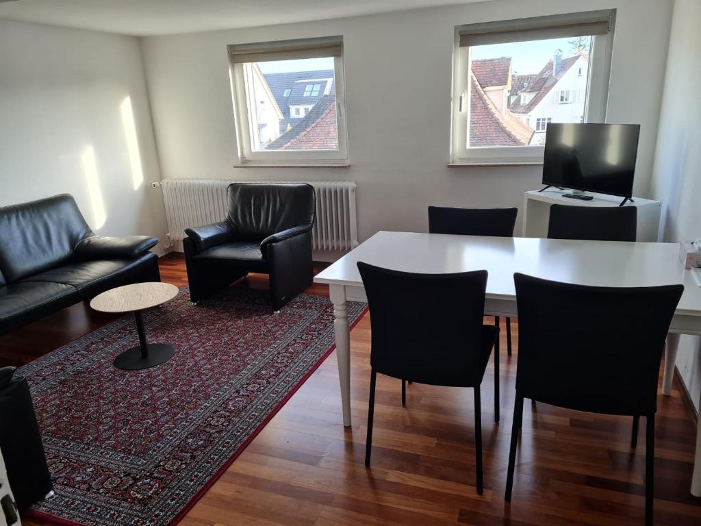 ein Wohnzimmer mit einem Tisch und Stühlen in der Unterkunft Appartment Himmelblau in Friedrichshafen