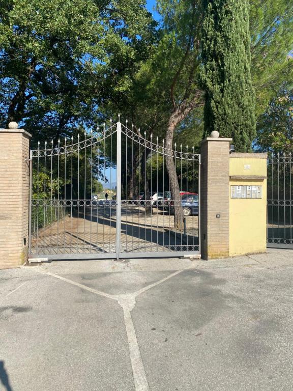 un cancello in un parcheggio con un albero di La Casa di Mimì a Foligno