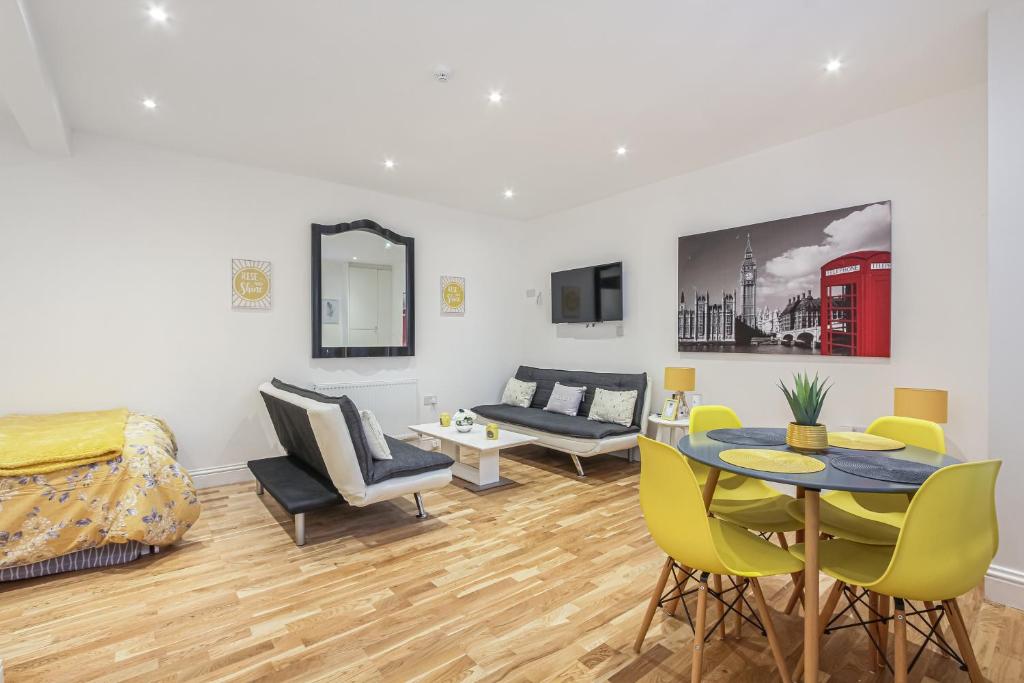 a living room with a table and chairs and a couch at Deluxe Flat A in Kensington Olympia in London