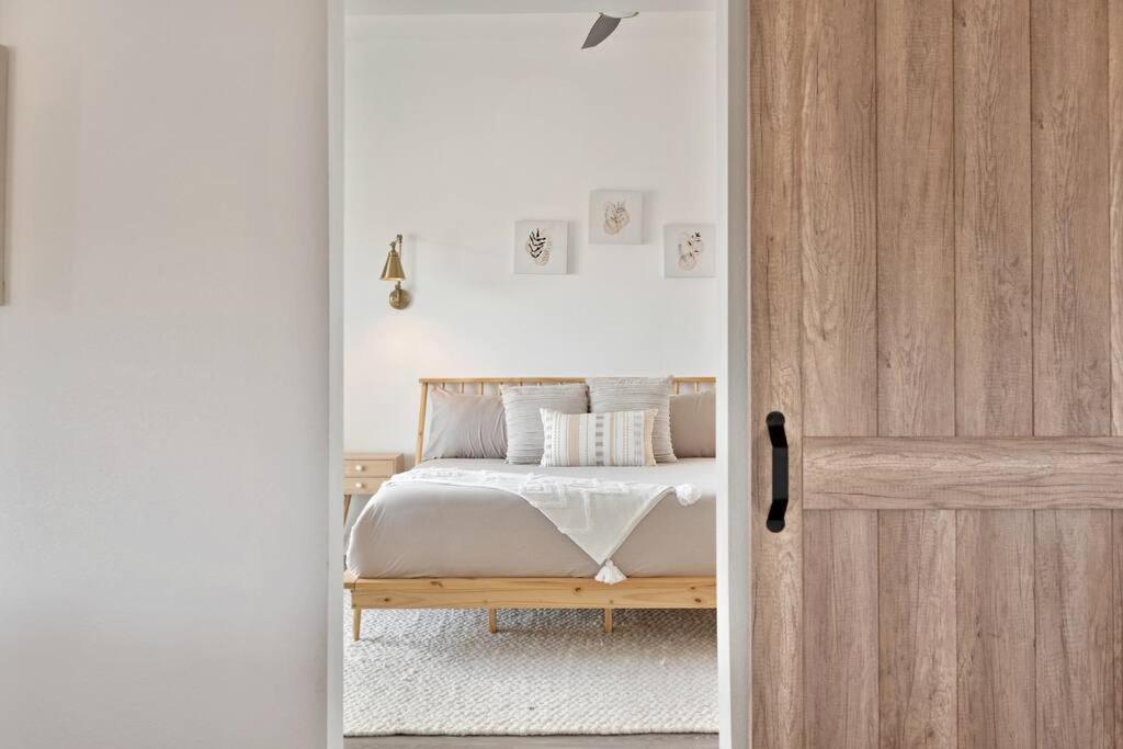 1 dormitorio con 1 cama y puerta de madera en Beautiful newly remodeled home, near JT Park en Joshua Tree