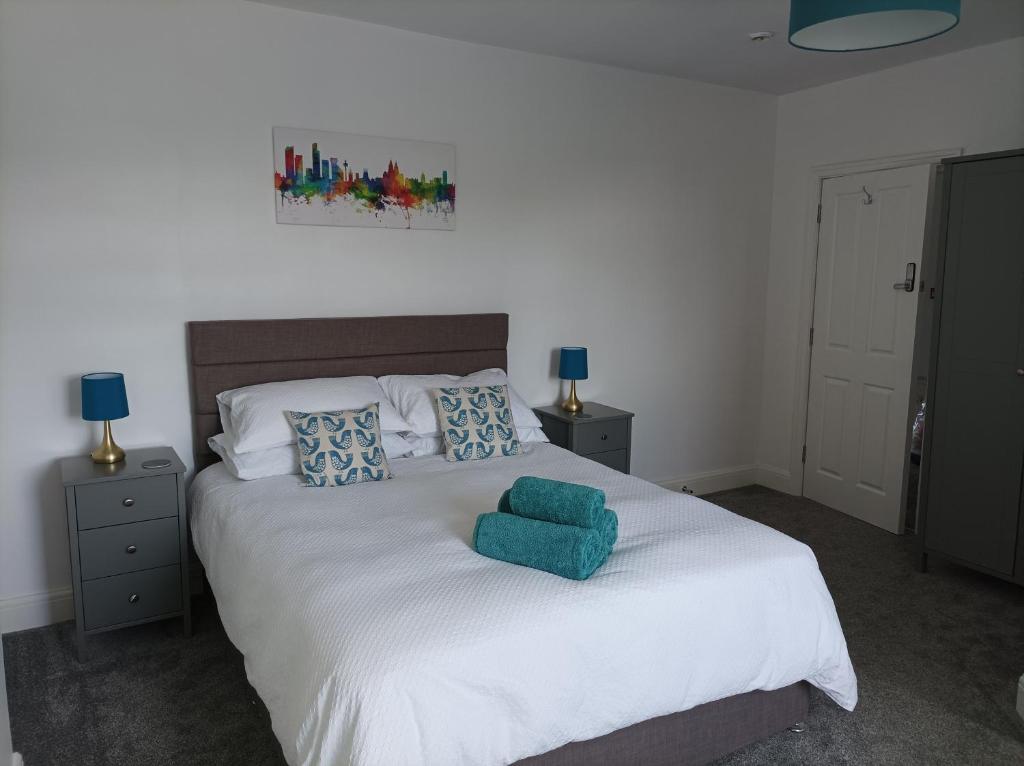 a bedroom with a large white bed with blue pillows at Victorian Renovation Room 7 in Liverpool