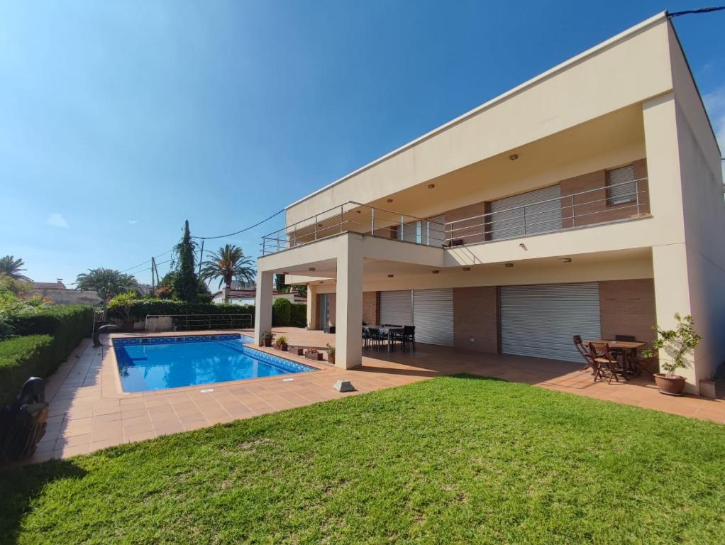a house with a swimming pool and a yard at VILLA MARICEL in Alcanar