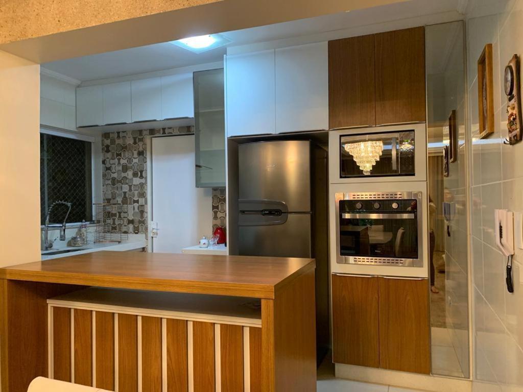 a kitchen with a stainless steel refrigerator and a microwave at Apartamento Novissimo Aquarius II in Poços de Caldas