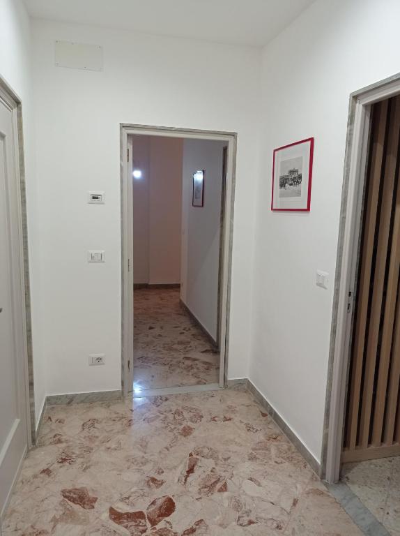 an empty hallway with white walls and a doorway at CasaRA in Bari