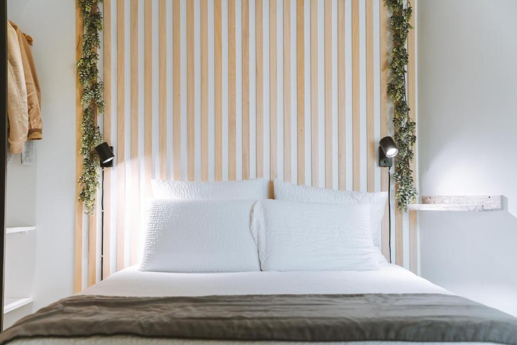 a bedroom with a bed with a striped headboard at SKY - Gîte meublé & confort Drôme - Écolodgîte in Laveyron