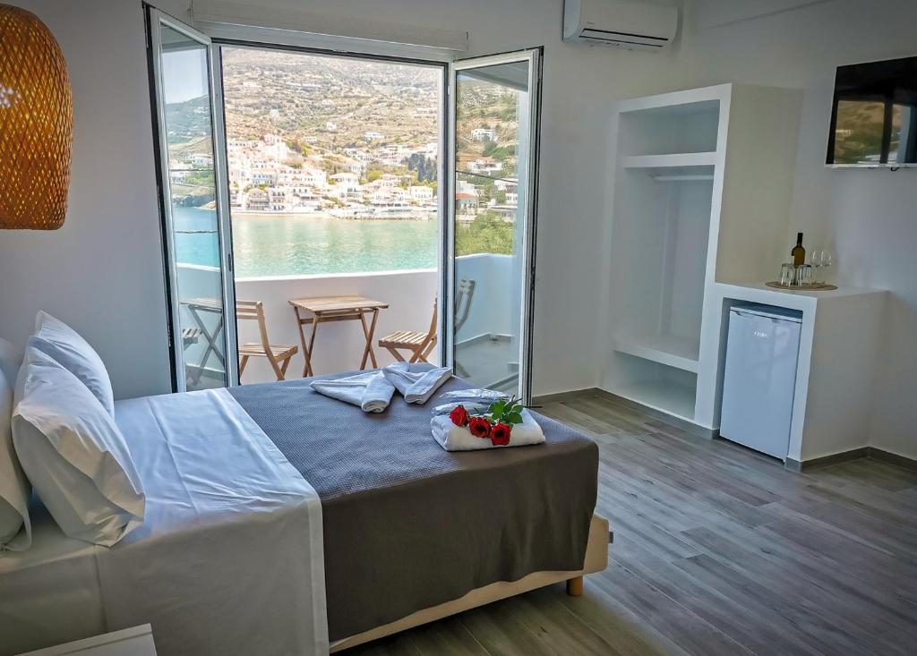 a bedroom with a bed and a large window at Galazio Rooms & Suites in Batsi