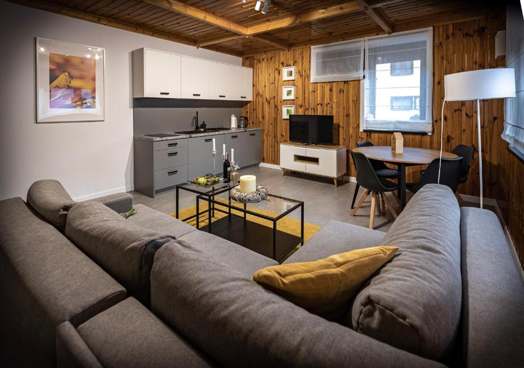a living room with a couch and a kitchen at Apartamenty MIODZIO in Szczyrk