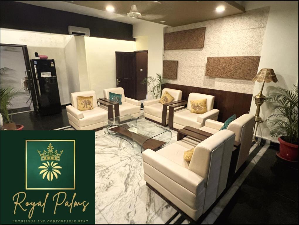 sala de estar con sofás blancos y mesa de cristal en Royal Palms Luxury Service Apartment, en Nagpur