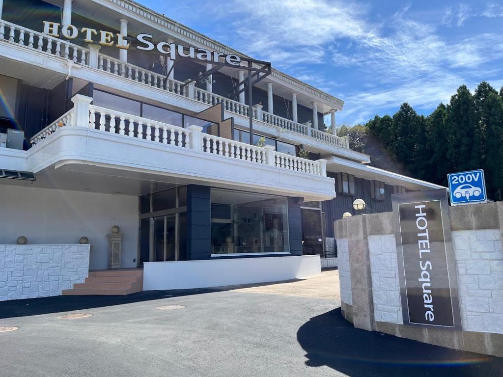 un hotel con una señal de hotel delante de él en Hotel Square FujiGotemba en Gotemba