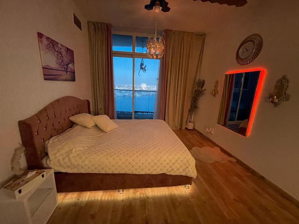a bedroom with a bed and a large window at Creekview Luxury Apartment in Ajman 