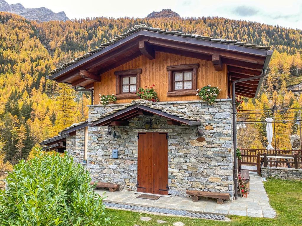 una piccola casa con una porta in legno in montagna di La terrazza a Ceresole Reale