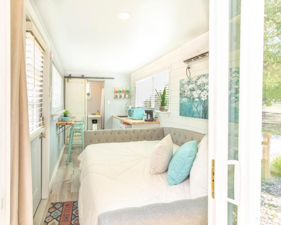 a small bedroom with a bed and a kitchen at The Container Retreat @ 290 Wine Trail #1 Escape to Hye, TX in Hye