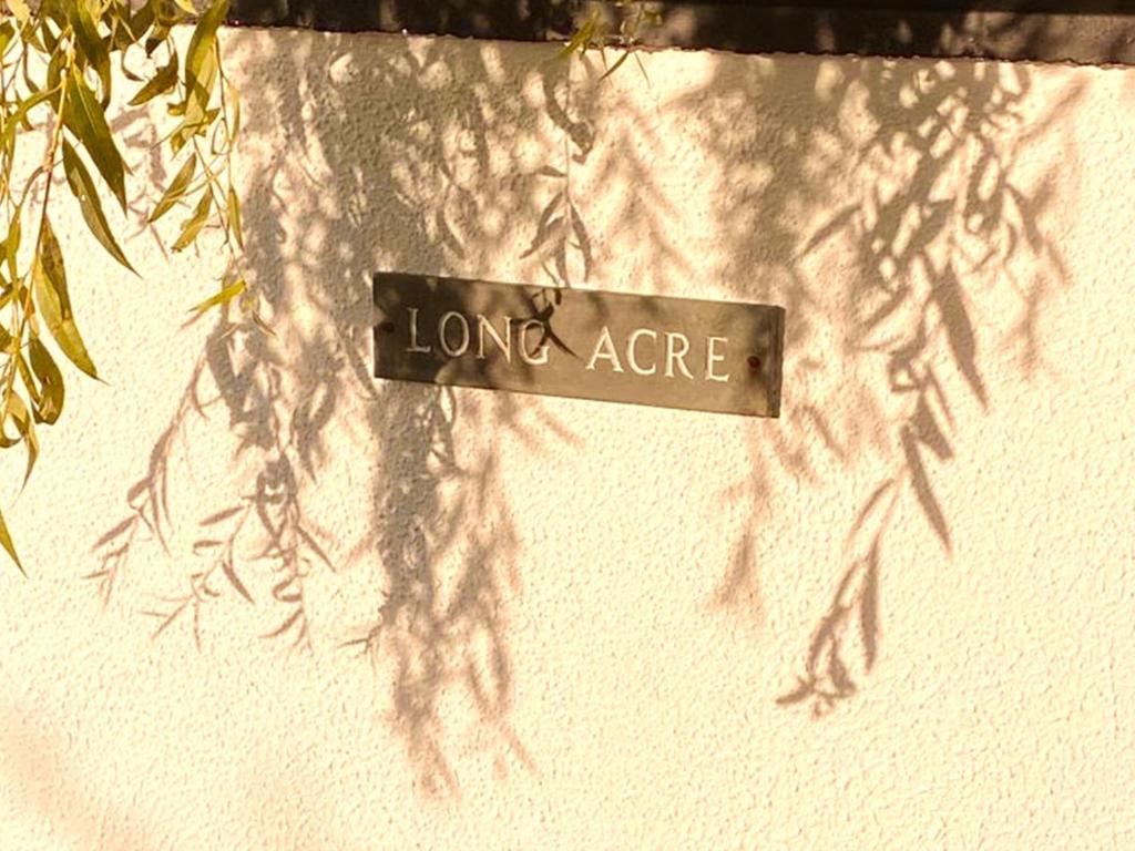 un panneau indiquant de longues acres suspendues sur un mur dans l'établissement Long Acre Lodge, 