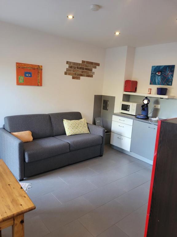 a living room with a couch and a kitchen at Ferienwohnung am Minoritenhof in Sinzing