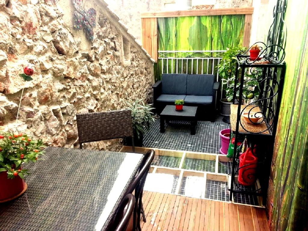 une terrasse avec un canapé, une table et des plantes dans l'établissement Appartement avec terrasse 10M2 centre ville 300 m Sète, à Sète